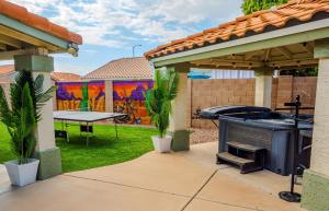 a backyard with a grill and a ping pong table at Summer Splash Pool, Spa & Game Room in Mesa