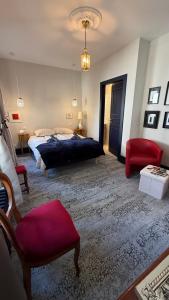 a bedroom with a bed and a red chair at Villa Bartholdi in Colmar