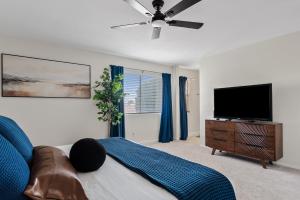 a living room with a couch and a flat screen tv at Summer Splash Pool, Spa & Game Room in Mesa