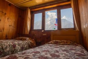 Habitación con 2 camas y ventana con vistas a las montañas en Sherpa Panorama Hotels, en Khumjung
