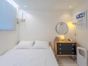 ein Schlafzimmer mit einem Bett, einer Kommode und einem Spiegel in der Unterkunft Stay in Seoul Seoul Station 5min walk in Seoul