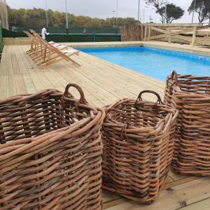 three baskets on a deck next to a swimming pool at Q Village - Poleg Beach in Netanya +18 photos