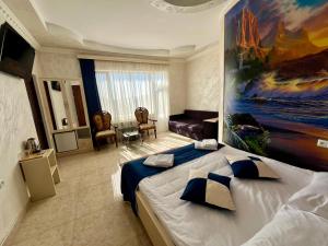 a bedroom with a large bed with a painting on the wall at Kirch Hotel & Restaurant in Goris
