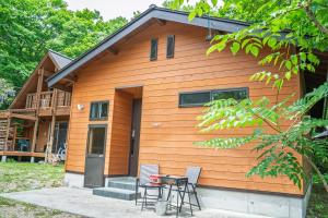 une maison avec une table et des chaises devant dans l'établissement BETSUINN MINI, à Hakuba