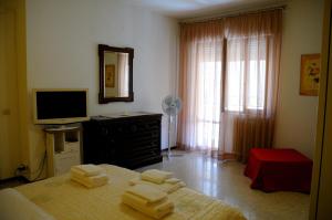 a bedroom with a bed and a television and towels at Sole e Sale in San Benedetto del Tronto