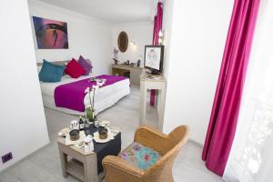 a bedroom with a bed and a table and a chair at Cristal Hôtel & Spa in Cannes