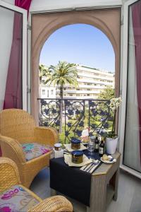 a room with a table and chairs and a balcony at Cristal Hôtel & Spa in Cannes