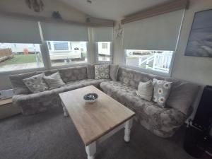 a living room with a couch and a coffee table at 3-Bed Caravan Sleeps 8 Pool & Beach in Chapel Saint Leonards +19 photos