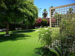 a park with green grass and trees and flowers at Q Village - Poleg Beach in Netanya