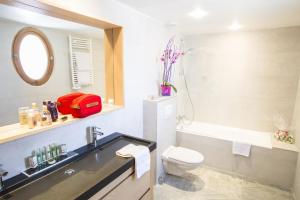 a bathroom with a sink and a toilet and a mirror at Cristal Hôtel & Spa in Cannes