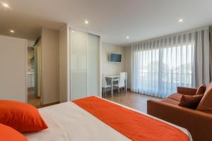 a bedroom with a bed and a couch and a table at Apartamentos La Bolera in Isla
