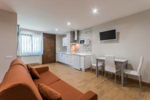 a living room with a couch and a dining room at Apartamentos La Bolera in Isla