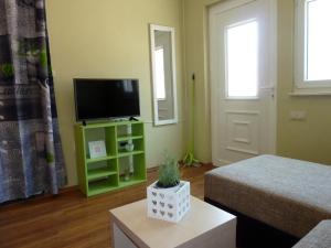 a living room with a television and a green cabinet at Apartments Tamaris in Trogir