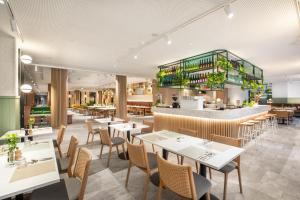 a restaurant with tables and chairs and a bar at Holiday Inn Melbourne Bourke Street Mall by IHG in Melbourne +139 photos