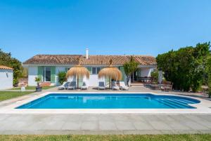 a villa with a swimming pool and a house at Mallorquin Oasis with natural pool 5min from the beach in Port de Pollensa