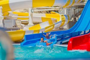 two people on a water slide at a water park at Louis St. Elias Resort & Waterpark in Protaras