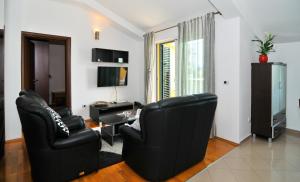 a living room with two black chairs and a table at City Center Apartments in Tivat