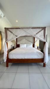 a bedroom with a bed with a canopy at Vila Billy II in Munggu