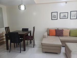 a living room with a couch and a table at Pasay 1BR Family Staycation with Parking in 150 Newport Boulevard near Resort World & NAIA T3 in Manila