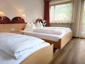 een hotelkamer met twee bedden en een raam bij Pension Atlantic in Badia +18 foto's