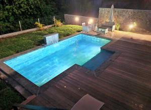 a swimming pool in a backyard at night at La villa canne à sucre in Sainte-Suzanne