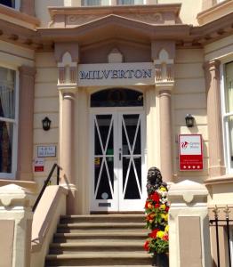 un edificio con una puerta con un cartel. en Milverton House en Llandudno