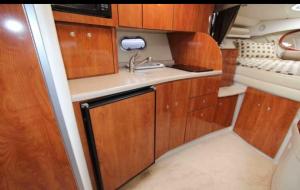 a small kitchen with wooden cabinets and a sink at bateaux à quai Porquerolles in Hyères +2 photos