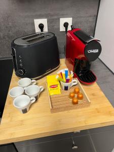 a counter with a toaster and cups and utensils at Apartment - Abbaye aux Dames, reserved parking in Saintes +8 photos
