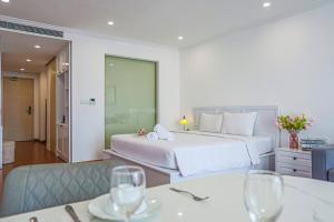 a hotel room with a bed and two tables with wine glasses at La Casa Nha Trang - GoldCoast Tower, Yellow-Amber-Beach & Lotte Mall in Nha Trang