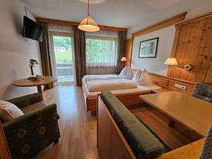 een hotelkamer met een bed en een bank bij Pension Atlantic in Badia +18 foto's