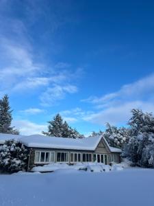 a house covered in snow with trees at Tekapo1929 Lakefront Villa in Lake Tekapo