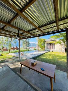 a wooden table under a pavilion with a view of a yard at Segara Healing Bali Glamping With Hot Spring in Kubupenlokan