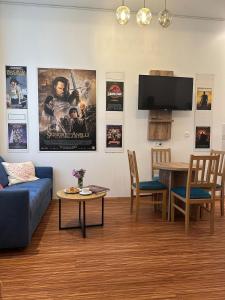 a living room with a blue couch and a tv at PostersApt4-Cozy Cinema Vibes in Größing