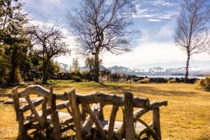 a wooden fence in a field with mountains in the background at Tekapo1929 Lakefront Villa in Lake Tekapo