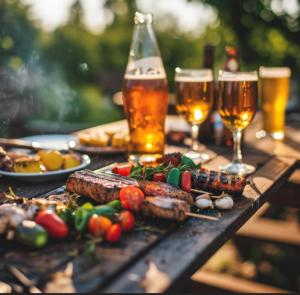 ein Tisch mit Essen und zwei Gläsern Bier in der Unterkunft Smith 夫婦 in Setouchi