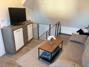 a living room with a couch and a tv at Lühnder Ferienwohnung in Algermissen