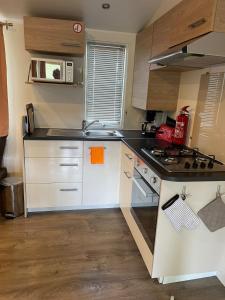 a kitchen with a sink and a stove top oven at Bungalow 6 à 8 personnes Valras Plage in Sérignan