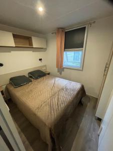 a bedroom with a bed and a window at Bungalow 6 à 8 personnes Valras Plage in Sérignan