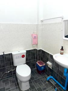 a bathroom with a toilet and a sink at Wealthy Homestay in Betong +4 photos
