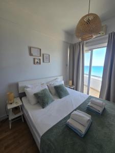 a bedroom with a bed with a view of the ocean at Lazuli Sea View Beachfront- Ap 61 in Larnaca