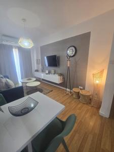 a living room with a table and a clock on the wall at Lazuli Sea View Beachfront- Ap 61 in Larnaca