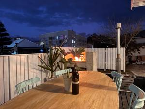 a bottle of wine sitting on a table on a patio at Beach House by Beach Collection Winelands in Strand