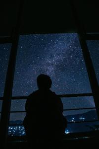 KalukにあるDaarapariの窓の前に座って星を眺めている人