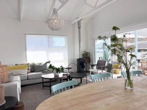 a living room with a table and a couch at Beach House - by Beach Collection in Strand