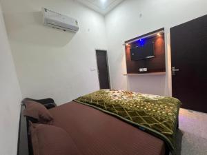a small room with a bed and a television at Bajrang seva dham in Mathura