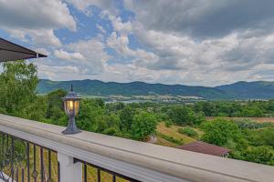 a lamp on a balcony with a view of the mountains at Villa High Point in Pravets +40 photos