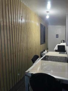 a room with wooden walls and tables and chairs at Freundliche Kammer Transient House in Dahikan