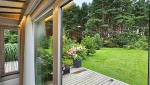 Blick auf einen Garten von der Veranda eines Hauses in der Unterkunft Nemirsetos kopos in Palanga