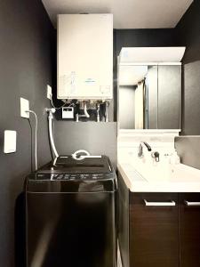 a kitchen with a black refrigerator and a sink at Oji正和ビル in Tokyo +26 photos