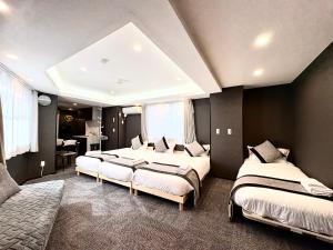 a bedroom with three beds in a room at Oji正和ビル in Tokyo